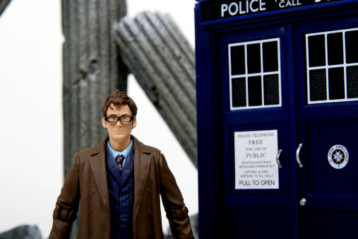 Vancouver, Canada - February 17, 2014: A toy TARDIS, with the tenth Doctor, from Dr. Who, against a white background. The TARDIS is the Doctor's main form of travel, a time machine and spaceship that is larger on the inside. Doctor Who is created by the BBC.