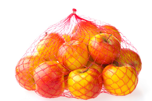 packed heap of apples- type topaz-  in red plastic net, white background