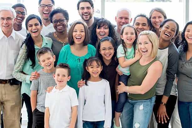 Family Reunion A multi-ethnic family group standing together happily while smiling and looking at the camera. family reunion stock pictures, royalty-free photos & images