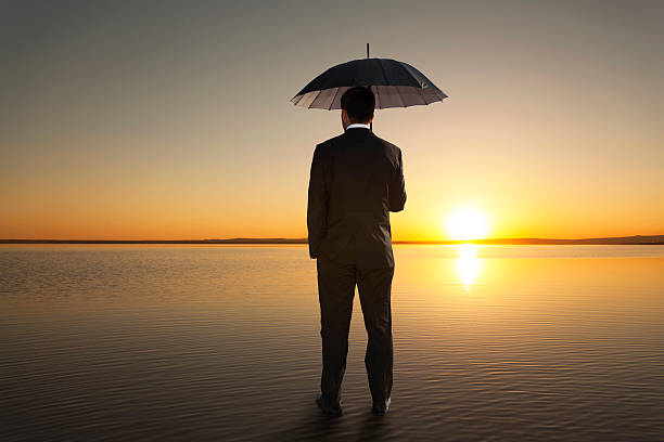 istock Man in black suit with a black umbrella On Salt Lake 478224688