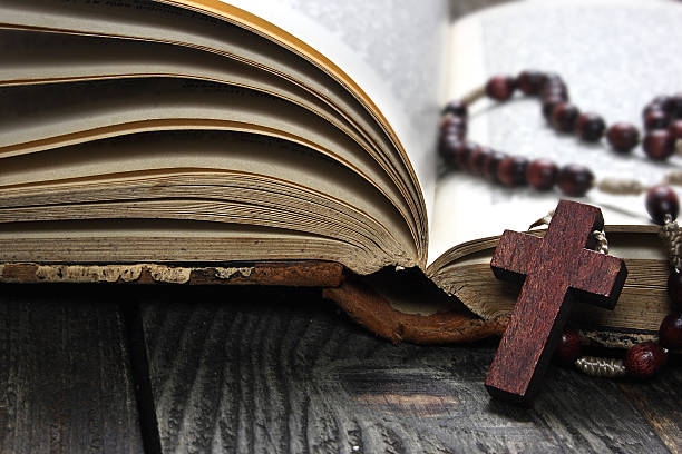 istock Rosary and open book on  wooden table 478226477