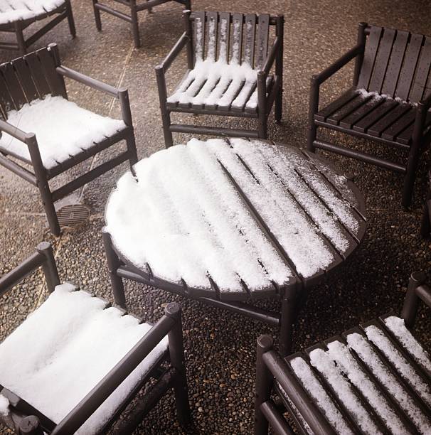 Mesa redonda e cadeiras com neve sobre eles - fotografia de stock