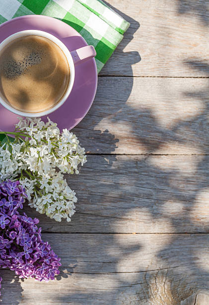 istock Coffee cup and colorful lilac flowers on garden table 478228304