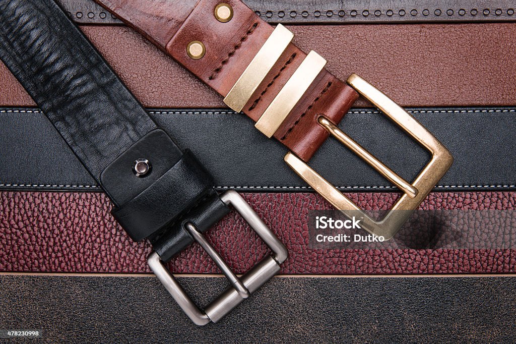 Close-up of two men belts Close-up of two men belts over leather strips background 2015 Stock Photo