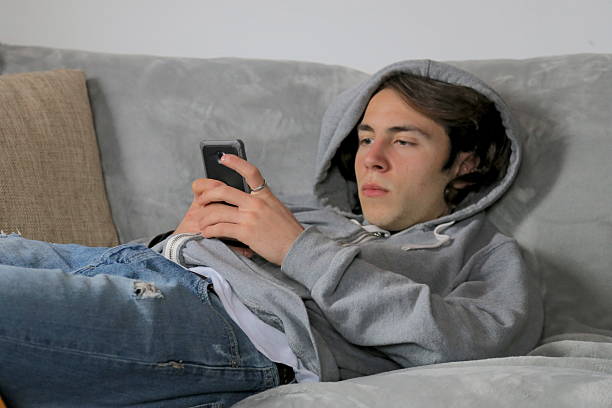 Teenager  typing on phone stock photo