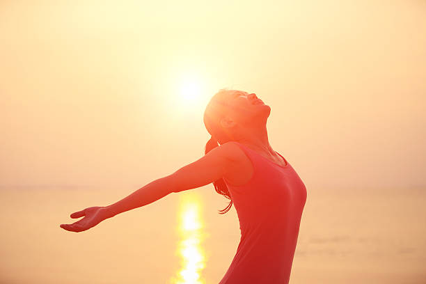 istock cheering  woman open arms under sunrise on beach 478234071
