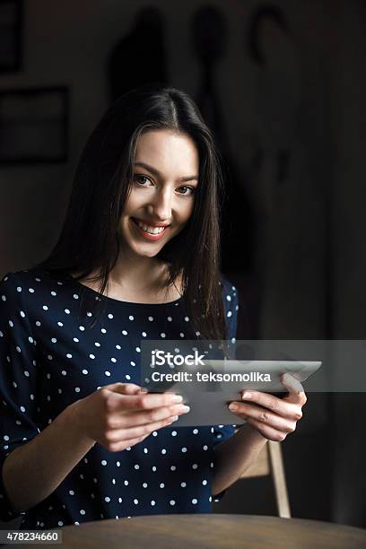 Beautiful Girl Working On A Tablet And Smiling Stock Photo - Download Image Now - 2015, Adult, Adults Only