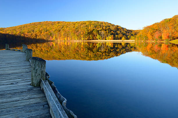 Mountain Lake with Dock Surrounded by Autumn Trees stock photo
