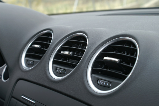 Triple oval air-vents in the centre of a modern car's dashboard