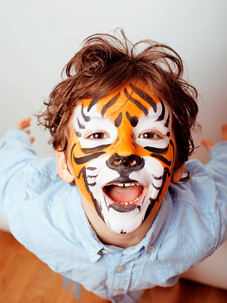 小さなかわいい男の子 faceart でのバースデーパーティーのクローズアップ - face paint child animal little boys ストックフォトと画像