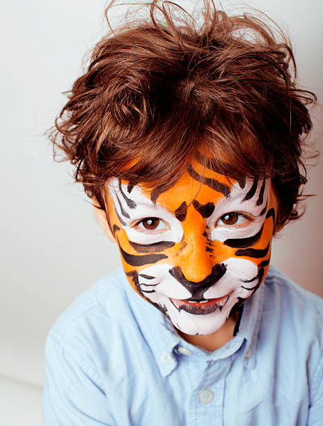 小さなかわいい男の子 faceart でのバースデーパーティーのクローズアップ - face paint child animal little boys ストックフォトと画像