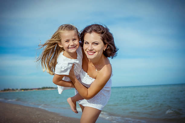 istock Happy beautiful mother and daughter enjoying beach time 478242082