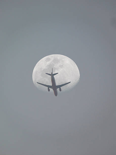 istock Passenger plane flying against the moon, low angle view 478242727