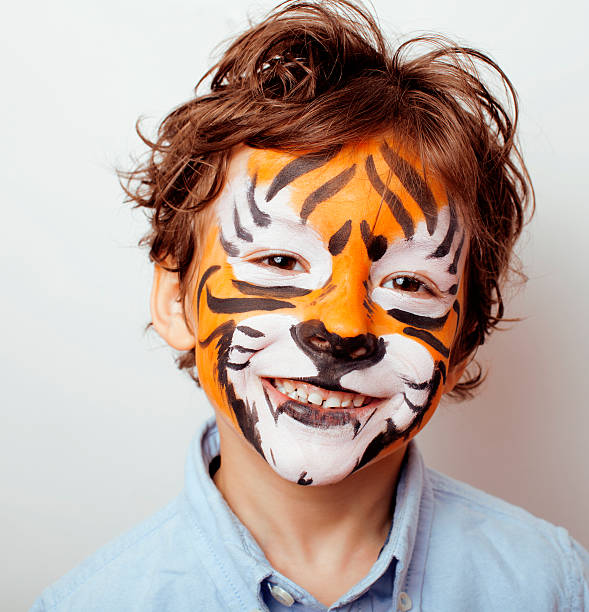 little cute boy with faceart on birthday party close up little cute boy with faceart on birthday party close up, emotional tiger roaring face paint stock pictures, royalty-free photos & images