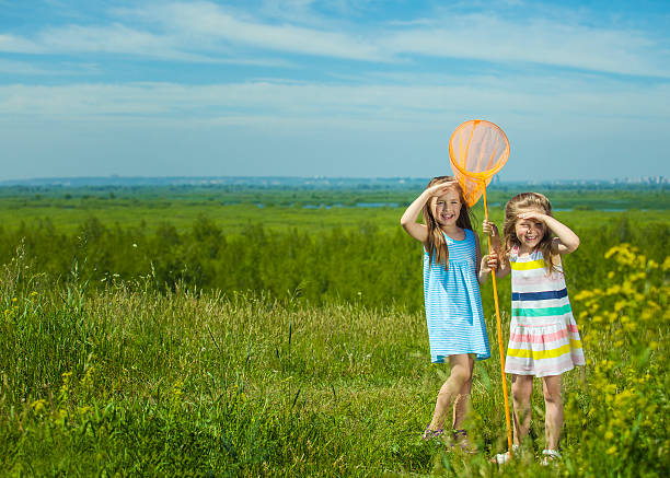 istock Kids summer in the meadow with orange net 478247896