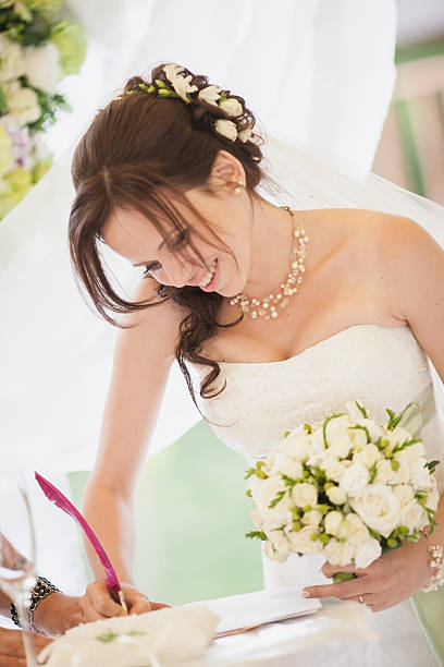 istock bride signing wedding certificate in park 478248439