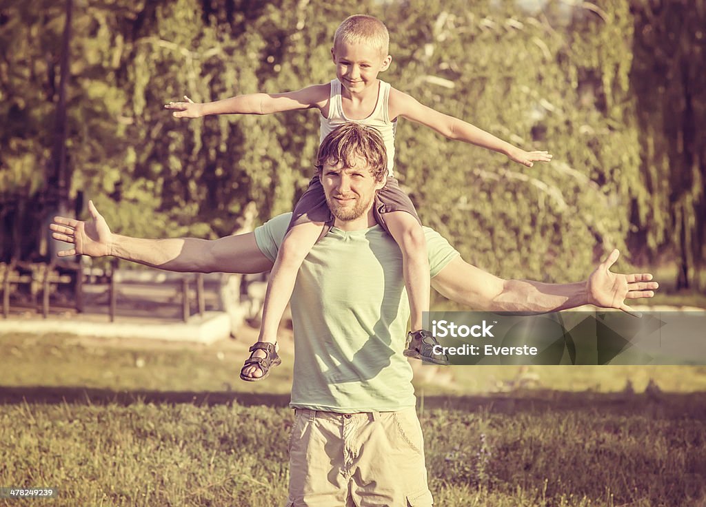 Family Father Man and Son Boy sitting on shoulders Outdoor Family Father Man and Son Boy sitting on shoulders Outdoor Happiness emotions Lifestyle with summer nature on background Family Stock Photo