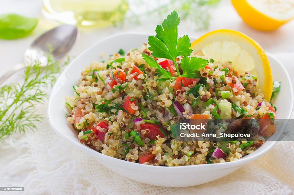 Tabbouleh salad with quinoa, parsley and vegetables Tabbouleh salad with quinoa, parsley and vegetables on white background Quinoa Stock Photo