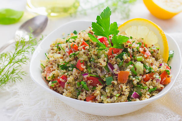 Tabbouleh salad with quinoa, parsley and vegetables Tabbouleh salad with quinoa, parsley and vegetables on white background quinoa photos stock pictures, royalty-free photos & images