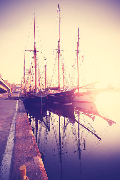 Vintage stylized sailing boats at sunrise, waterfront in Szczecin, Poland.