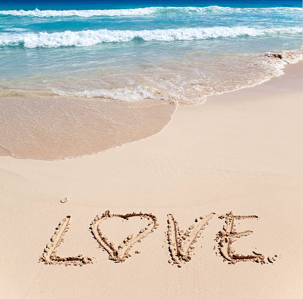 istock On sand at ocean edge it is written  LOVE 478252792