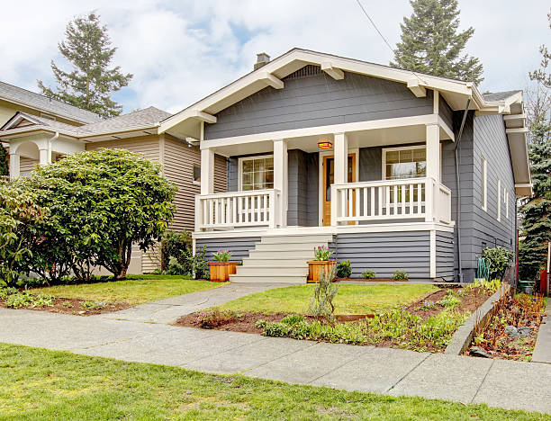 Grey craftsman style house with white porch. stock photo