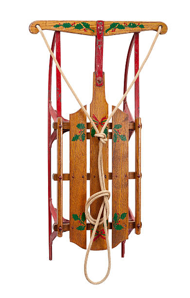 Antique hand painted, wooden sled from the 1930s.  The sled shows wood slats with a rope to use as steering.  The metal runners are red.  It is shot straight on as though it were hanging on a wall.  The image is isolated on a white background.