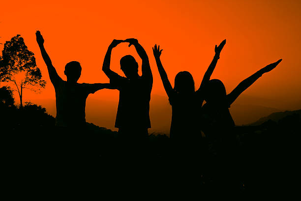 istock Friends raising hands, silhouette 478255260