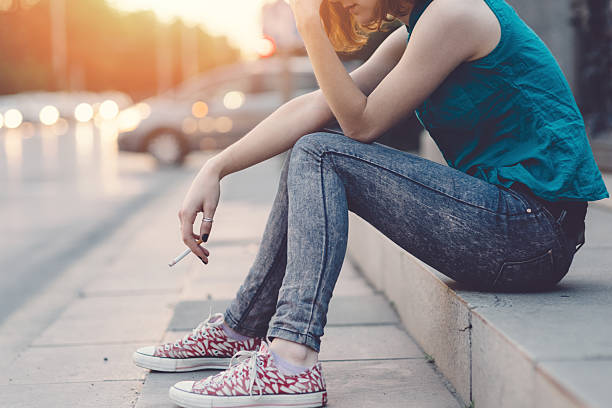 istock Depressed girl with cigarette outside 478255410