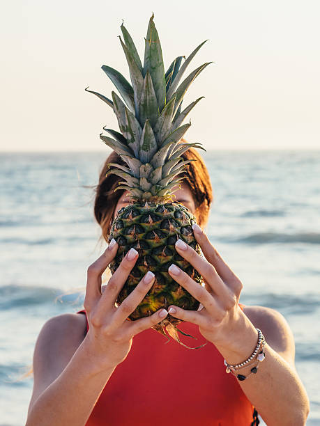 istock Young Woman Holding Pineapple On The Beach 478261264