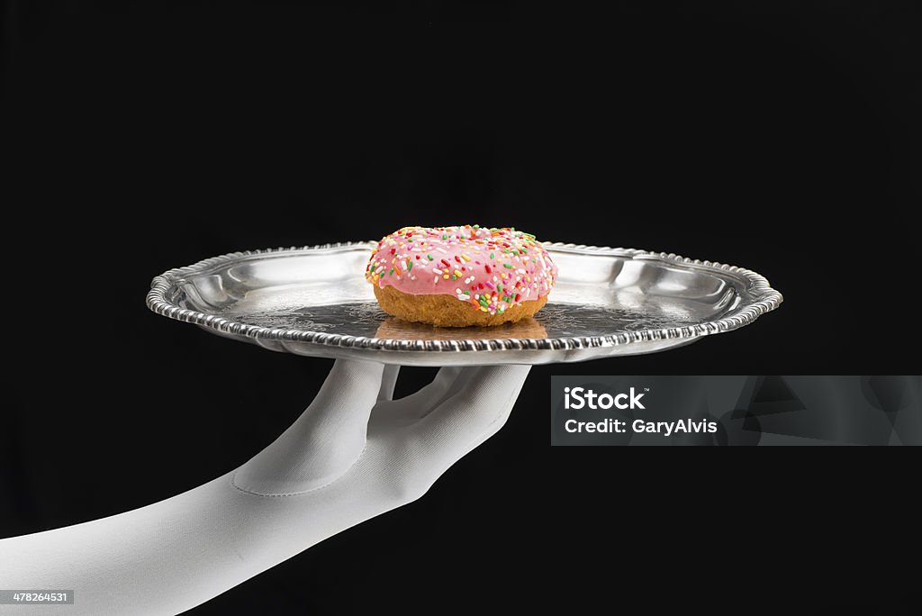Luxo-rosa donut fosco servido em uma bandeja de prata com mão com luvas brancas - Foto de stock de Bandeja royalty-free