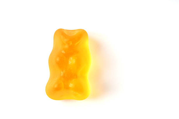 istock Orange gummy bear macro with shadow isolated on white background 478266354