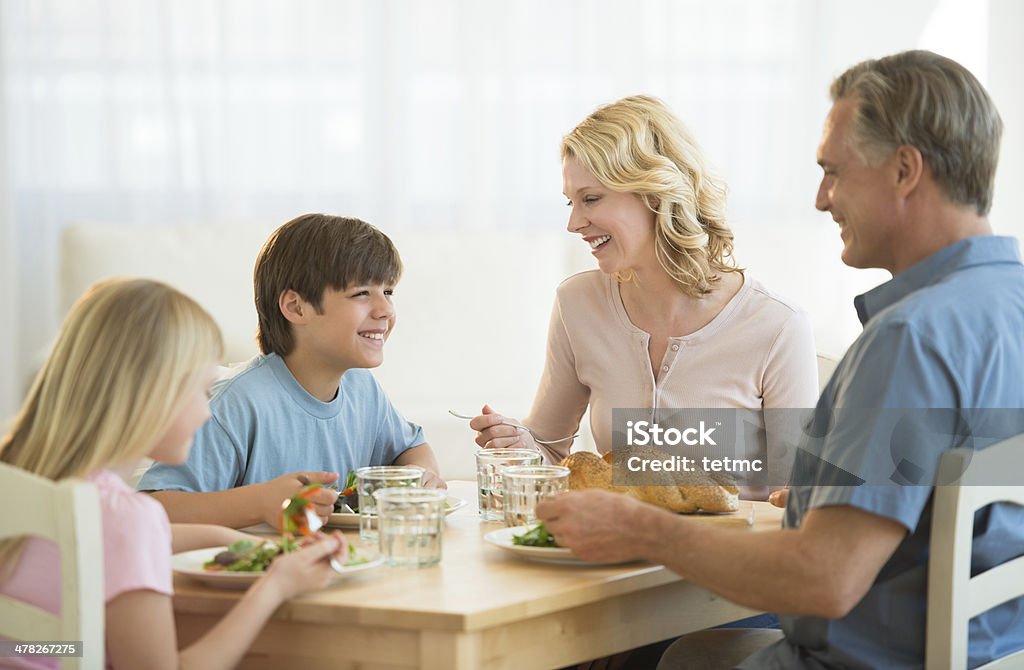 Семьи, имеющие еды на обеденный стол - Стоковые фото 10-11 лет роялти-фри