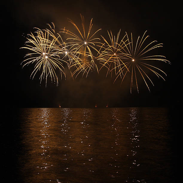Colorful fireworks with reflection on lake.