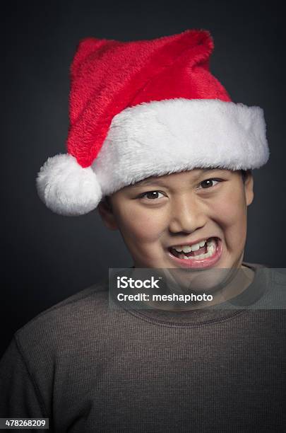 Felice Bambino Asiatico Per Natale Indossando Un Cappello Da Babbo Natale - Fotografie stock e altre immagini di Ambientazione interna
