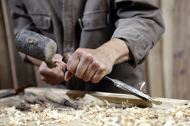 istock hands of carpenter with hammer and chisel in carpentry 478268638
