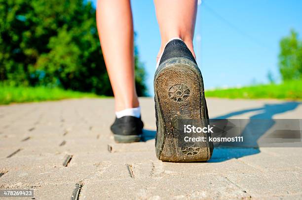 Female Legs In Sneakers Close Up Running Down The Road Stock Photo - Download Image Now