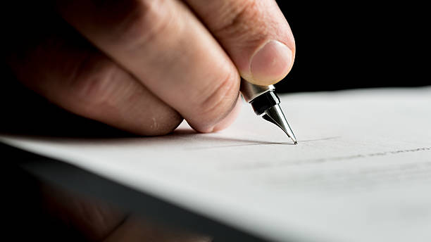 istock Hand of a businessman signing or writing document 478278126