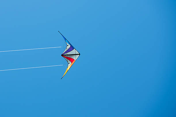 istock Kite with two white lines against bright blue background 478278776