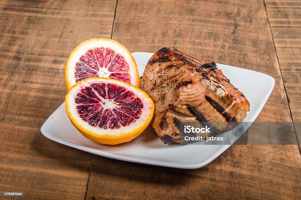 Tuna steak grilled with orange sauce Tuna steak grilled with blood orange sauce on plate 2015 Stock Photo