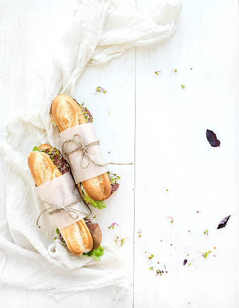istock Sandwiches with beef, fresh vegetables and herbs over white wood 478287740