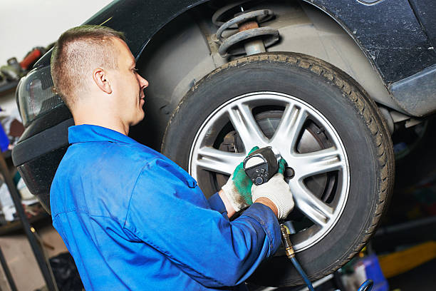 istock auto mechanic screwing car wheel by wrench 478288148