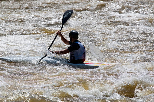 Salida, Colorado, USA - June 20, 2015: Competitors race through gates on a course in the Arkansas River in the Salida Whitewater Park while spectators watch from the banks in the 2015 Fibark Whitewater Festival near Sackett Avenue in Salida, Colorado