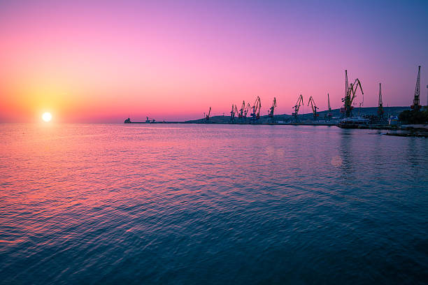 Sunrise over stone beach with port Sunrise over stone beach with port feodosiya stock pictures, royalty-free photos & images