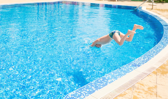 A boy jumping into swimming pool