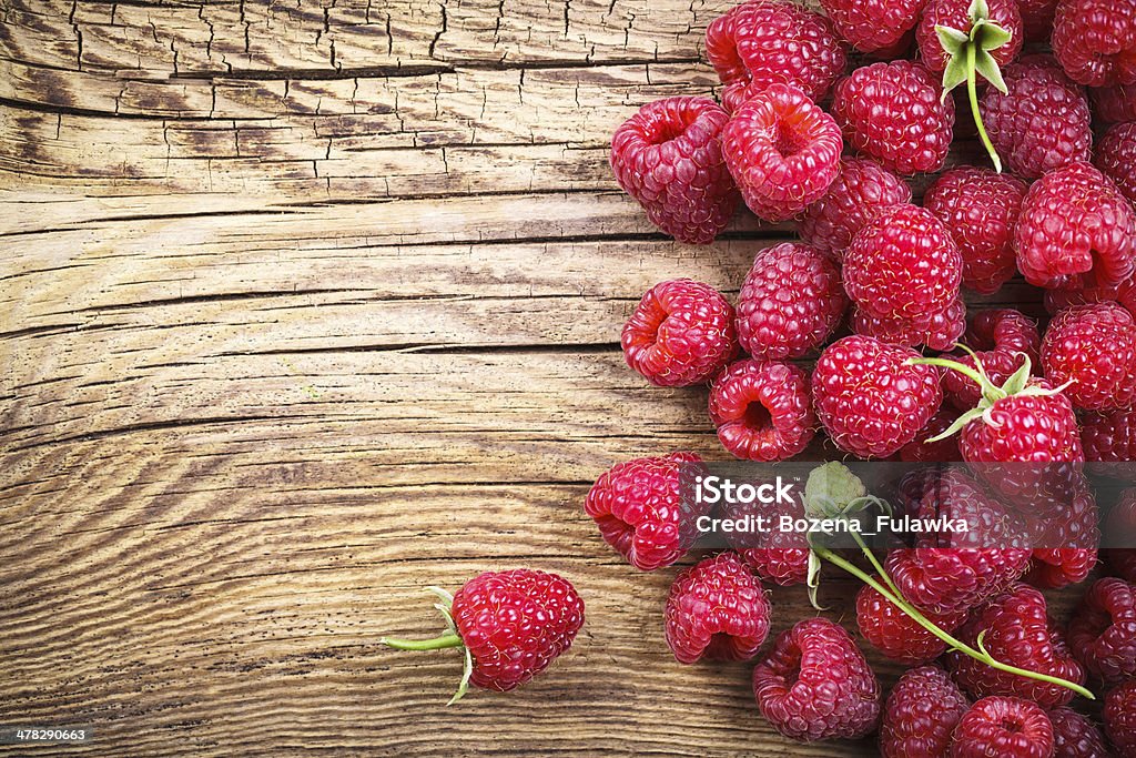 Raspberries Raspberries on wooden table background with copy space. Top view Berry Fruit Stock Photo