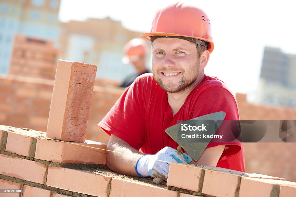 construction mason worker bricklayer construction worker. Portrait of mason bricklayer installing red brick with trowel putty knife outdoors Bricklayer Stock Photo
