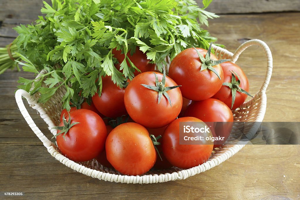 Tomates maduros frescos en una cesta en la tabla - Foto de stock de Agricultura libre de derechos