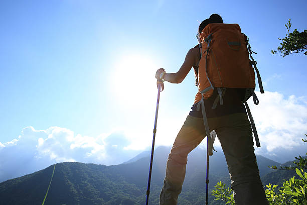 istock cheering woman hiker climbing to mountain peak 478296002