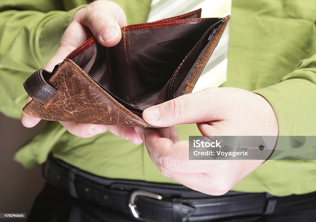 Empty wallet in male hands - poor economy Poor economy represented by empty wallet in businessman's hands Adult Stock Photo